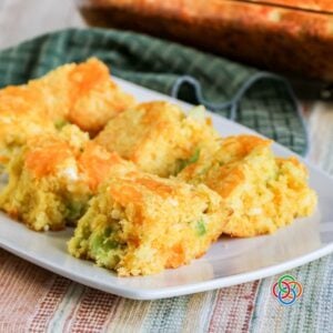Deliciously moist cornbread with cheddar broccoli onion and cottage cheese | Irish American Mom Close-up of moist broccoli cheddar cornbread squares with pieces of broccoli and onion throughout and a golden layer of melted cheddar cheese on top.