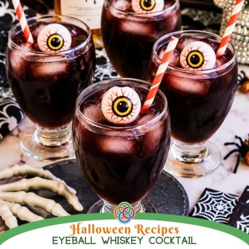 Halloween Recipe Eyeball Whiskey Cocktail | Irish American Mom Four dark Halloween whiskey cocktails served over ice in short-stemmed goblets, decorated with creepy eyeballs and red striped straws, with skeleton hands, spiders and cobweb decorations.