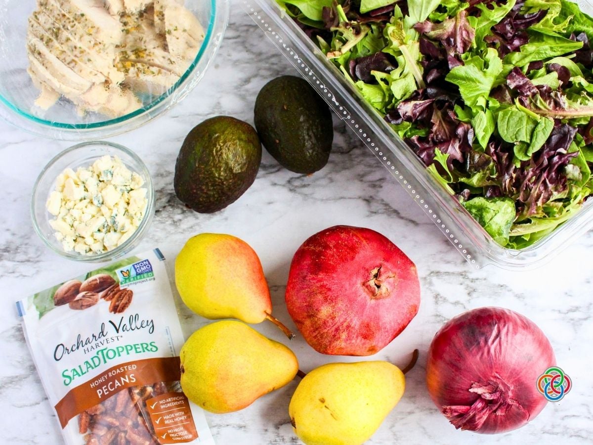 Ingredients for a Harvest Pear Salad | Irish American Mom Ingredients for a Harvest Pear Salad including fresh Bartlett pears, pomegranate, avocados, red onion, mixed salad greens, cooked turkey breast, crumbled Gorgonzola cheese and honey-roasted pecans.