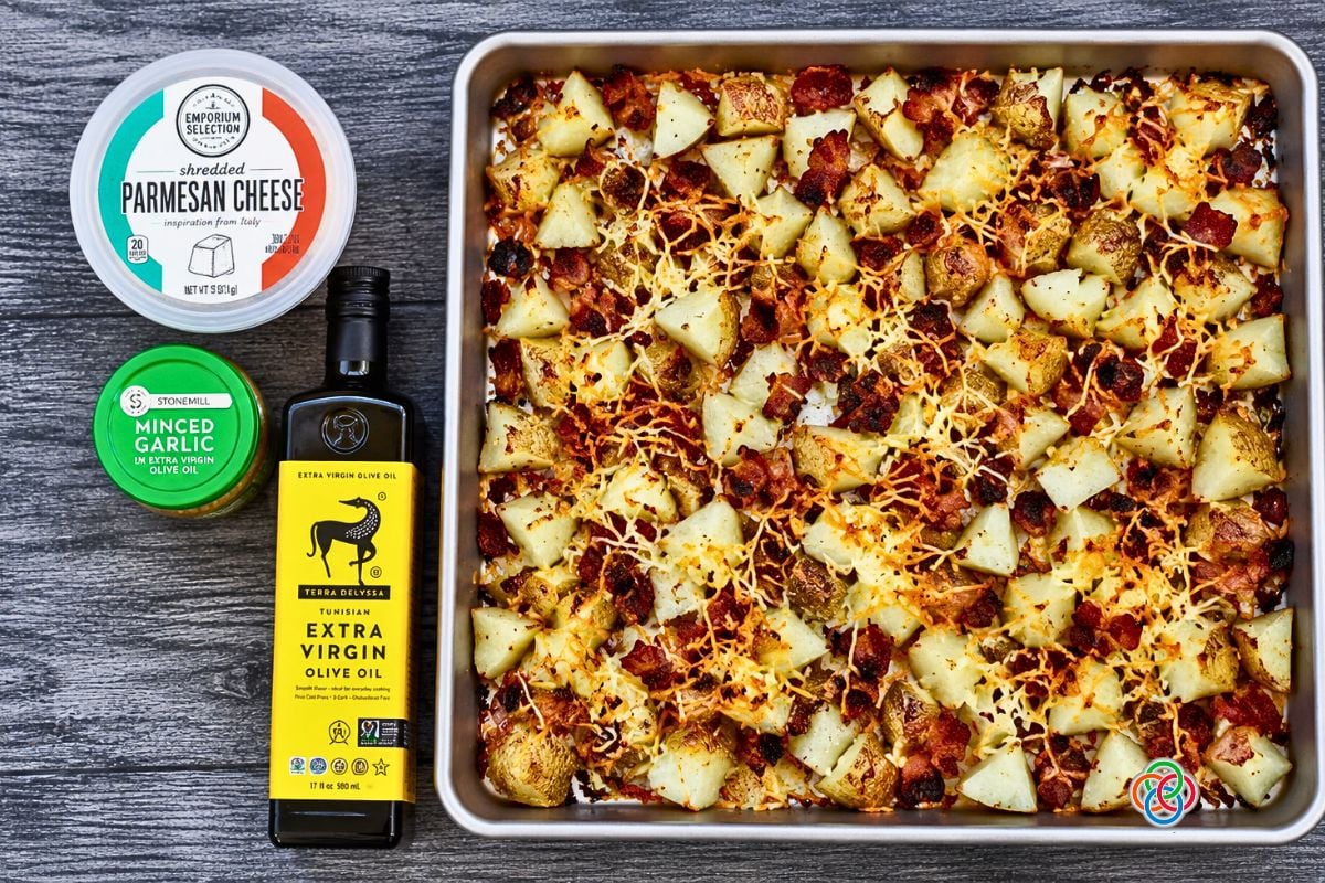 Roasted Bacon Parmesan Sheetpan Potatoes Just Out of the Oven | Irish American Mom Freshly roasted Bacon Parmesan Sheet Pan Potatoes with golden potato chunks, crispy bacon, garlic and browned melted Parmesan cheese on a baking sheet.
