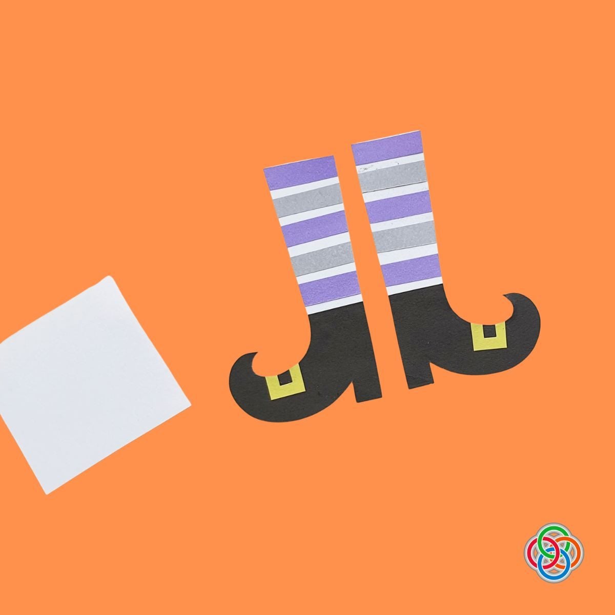 Striped witch legs and pointy shoes for a Halloween Bookmark | Irish American Mom Handmade paper witch legs with purple, gray and white striped stockings, black pointy curled shoes and yellow buckles, ready to be assembled into a Halloween bookmark.