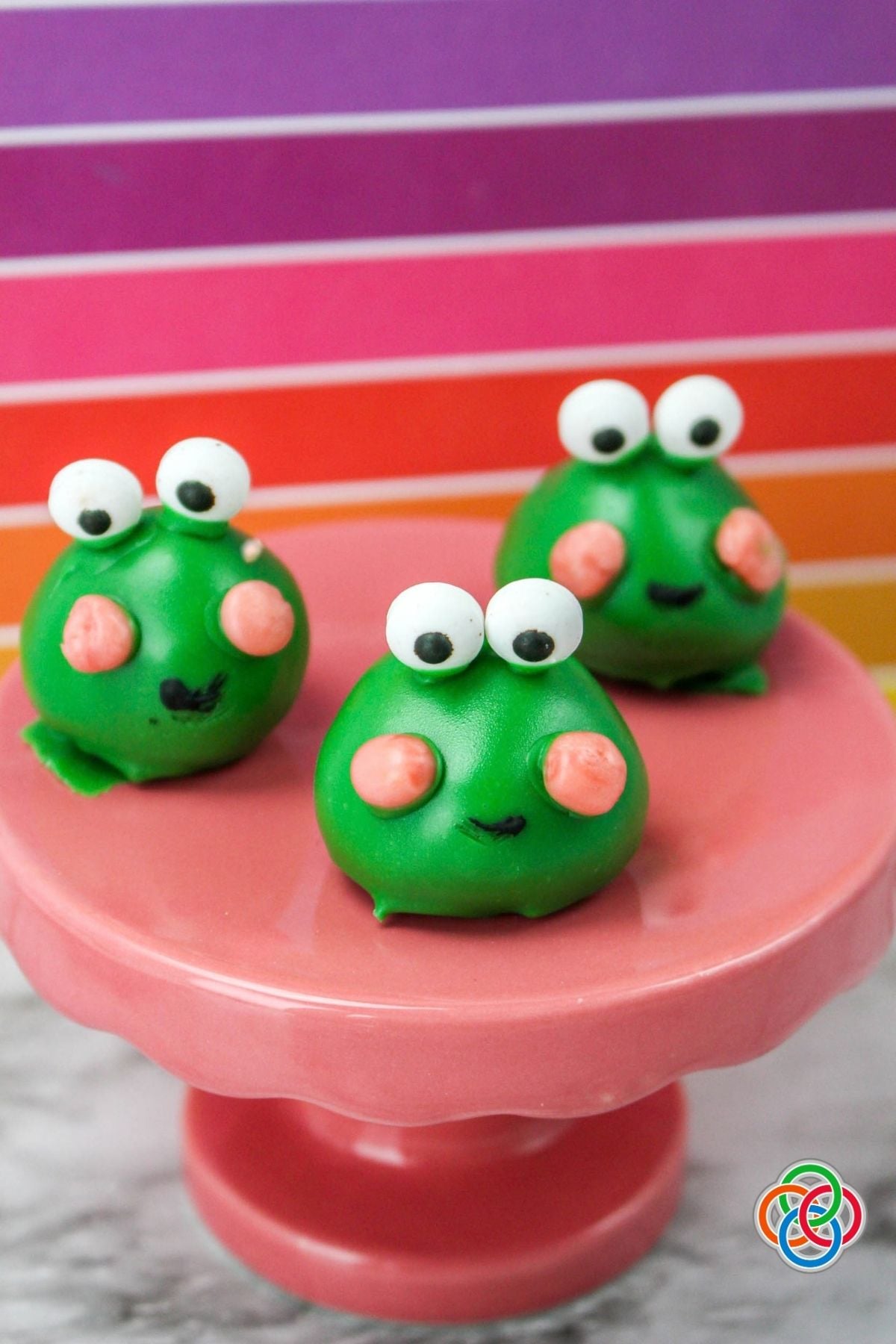 Adorable edible frog treats made with Oreo cookies and cream cheese | Irish American Mom Tree frog treats on a pink cake stand