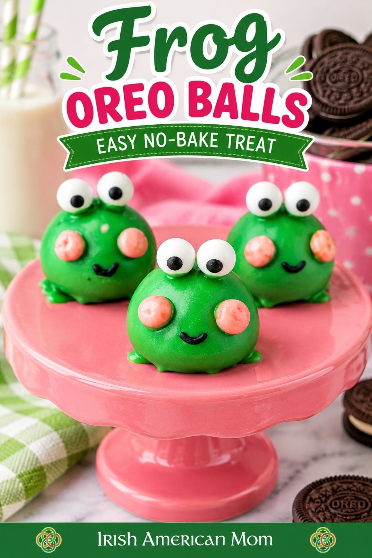 Frog Oreo Balls Easy No-Bake Treat | Irish American Mom Pinterest graphic featuring three adorable green Frog Oreo Balls with googly candy eyes, pink cheeks, and black icing smiles on a pink pedestal cake stand. Bold green and pink lettering reads "Frog Oreo Balls โ Easy No-Bake Treat," with Oreo cookies in the background and Irish American Mom branding at the bottom.