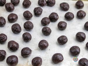 Oreo and cream cheese balls on a baking sheet | Irish American Mom Brown balls of cookie and cream cheese dough on a cookie sheet