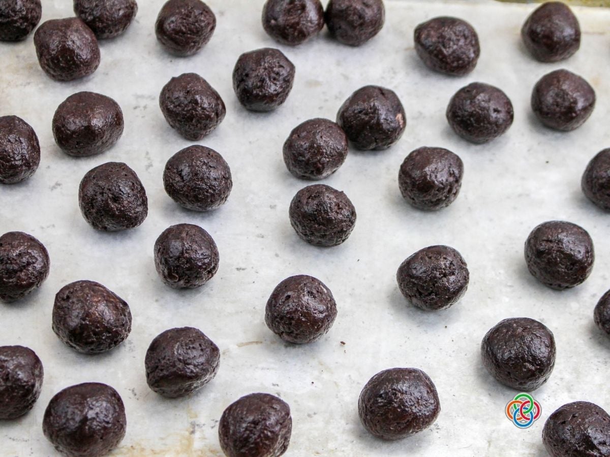 Oreo and cream cheese balls on a baking sheet | Irish American Mom Brown balls of cookie and cream cheese dough on a cookie sheet